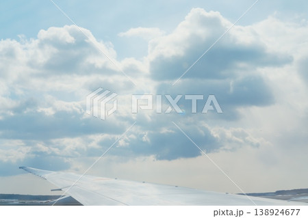 飛行機雲と青空、広がる雲海、地上風景を望む 138924677