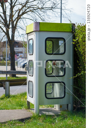 Public telephone booth by roadside, communication box for emergency calls, vintage street equipment, urban infrastructure and transport roadside scene 138924720