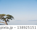 水面に映る孤高の松、遠景の山並みと静謐な空	 138925151