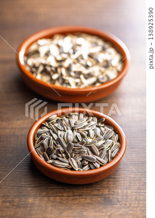Sunflower Seeds in Ceramic Bowls on Wooden Table. Raw Snack and Healthy Ingredient Close-Up 138925390