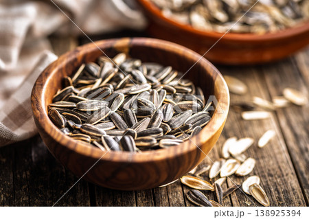 Sunflower Seeds in Bowl on Wooden Table With Scattered Shells Rustic Snack Background 138925394