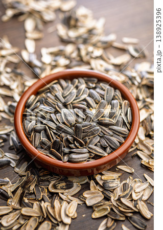Sunflower Seeds in Bowl on Wooden Table With Scattered Shells Rustic Snack Background Sunflower Seeds in Bowl on Wooden Table With Scattered Shells Rustic Snack Background 138925396