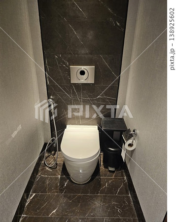 Small bathroom with a toilet and a trash can Small bathroom with a toilet and a trash can 138925602