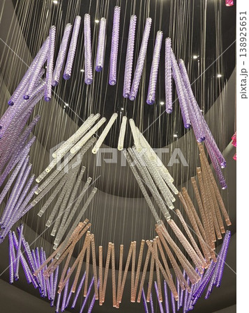 Large chandelier with many different colored glass rods hanging from it Large chandelier with many different colored glass rods hanging from it 138925651