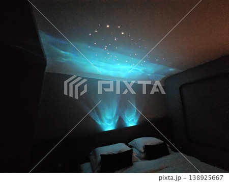 Bedroom with a blue light shining on the ceiling Bedroom with a blue light shining on the ceiling 138925667