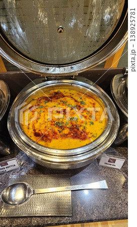 Large bowl of soup is sitting on a table Large bowl of soup is sitting on a table 138925781