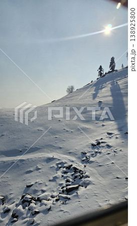 Snowy mountain with a bright sun shining on it Snowy mountain with a bright sun shining on it 138925800