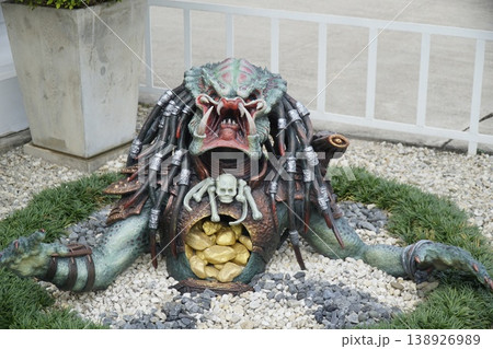 Large green monster with a gold coin in its mouth Large green monster with a gold coin in its mouth 138926989