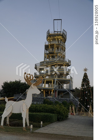 Tall building with a Christmas tree in front of it 138928005