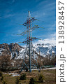 Power Line Tower Against Snowy Mountain Landscape 138928457