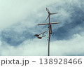 Wind Turbine and Solar Panel Against Cloudy Sky 138928466