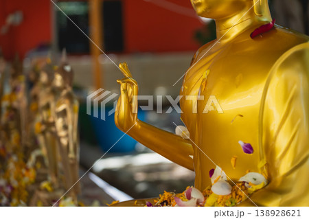 Golden Buddha Sculpture Surrounded by Colorful Flower Offerings in a Serene Spiritual Environment Capturing the Essence of Peace and Tranquility Golden Buddha Sculpture Surrounded by Colorful Flower Offerings in a Serene Spiritual Environment Capturing the Essence of Peace and Tranquility 138928621