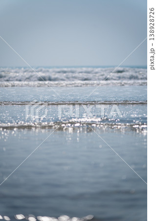 Calm Ocean Waves with Glimmering Sunlight Reflections on Water Surface in a Serene Coastal Landscape Calm Ocean Waves with Glimmering Sunlight Reflections on Water Surface in a Serene Coastal Landscape 138928726