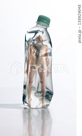 Man enclosed inside plastic bottle representing human dependence and environmental impact. 138929048