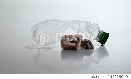 Curled woman hiding near plastic bottle expressing vulnerability and emotional shutdown Curled woman hiding near plastic bottle expressing vulnerability and emotional shutdown 138929049