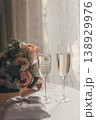 Two glasses of champaign for a broom and a bride. Wedding decor. Glasses with champaign. Bible and pillow with wedding rings. Romantic decor. Wedding anniversary. Love concept. Wedding celebration.  138929976