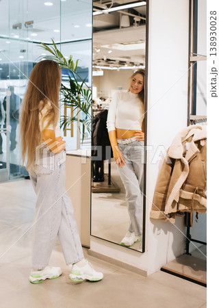Woman Checking Her Look in Shop Mirror Woman Checking Her Look in Shop Mirror 138930028