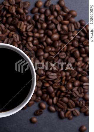 Roasted coffee beans and cup of coffee on granite background 138930070