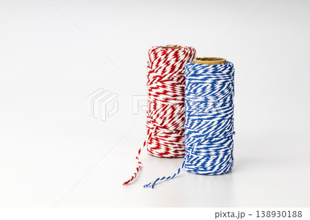 Colorful Red and Blue Striped Twine Spools with Decorative Striped Pattern for Gift Wrapping and Crafts Colorful Red and Blue Striped Twine Spools with Decorative Striped Pattern for Gift Wrapping and Crafts 138930188