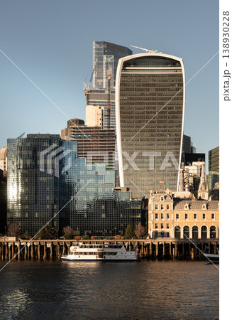London skyline tells a story of constant change, where historic brick meets modern glass. Low-rise gabled roofs form the city traditional foundation, while giants like the Walkie Talkie and the 138930228