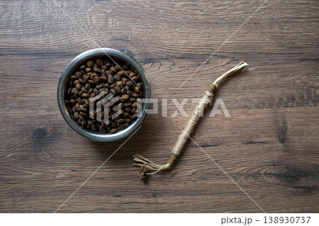 Cat dry food in bowl with matatabi stick toy on wooden background Cat dry food in bowl with matatabi stick toy on wooden background 138930737