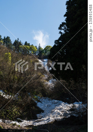 残雪と芽吹き始めた新緑の山肌と青空 138931488