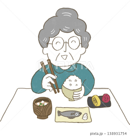おばあさんがお箸を持って日本食のご飯を食べている 138931754