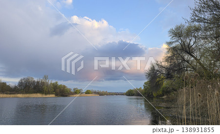 Spring river landscape with green trees, reflections, and pink clouds in the sky. Tourism. Spring river landscape with green trees, reflections, and pink clouds in the sky. Tourism. 138931855