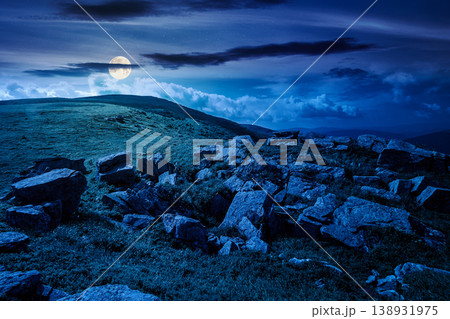 carpathian mountain summer landscape at night. full moon over alpine meadow with huge stones among the grass on top of the hillside near the peak of mountain range. mysterious dark sky view carpathian mountain summer landscape at night. full moon over alpine meadow with huge stones among the grass on top of the hillside near the peak of mountain range. mysterious dark sky view 138931975
