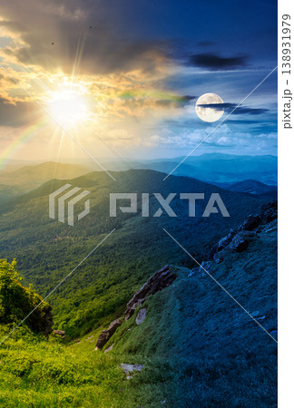 day meet night. mountainous countryside scenery. epic sky above the distant valley at twilight. sun and moon over green meadows and rocks on the hill. wonderful nature scenery of carpathian mountains 138931979