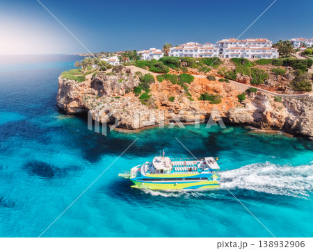 Aerial view of green yacht, sea with turquoise water, rocky coast Aerial view of green yacht, sea with turquoise water, rocky coast 138932906