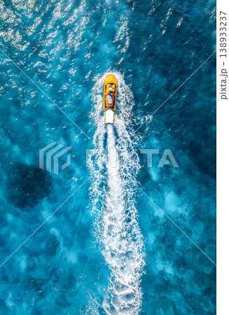 Aerial view of a yellow aquabike speeding through turquoise water Aerial view of a yellow aquabike speeding through turquoise water 138933237