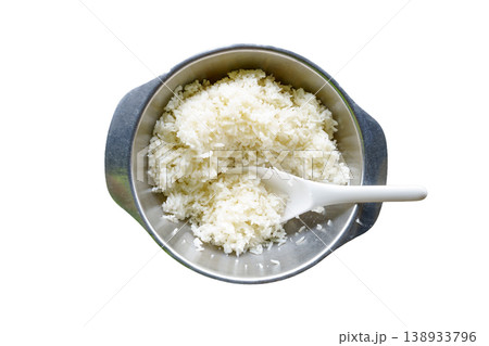 Top view of cooked jasmine white rice in a stainless steel bowl with a white plastic paddle. Isolated on white background. Clean food concept for culinary and healthy eating designs. Top view of cooked jasmine white rice in a stainless steel bowl with a white plastic paddle. Isolated on white background. Clean food concept for culinary and healthy eating designs. 138933796
