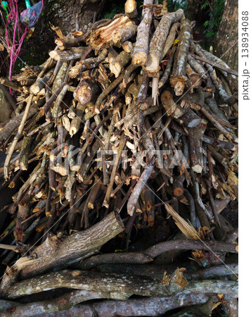 Large pile of chopped tree branches and broken logs with rough bark and splintered textures stacked outdoors for firewood and forestry cleanup themes 138934088