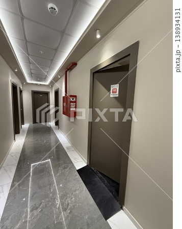 Fire exit door and safety equipment in modern building hallway with marble floor, emergency concept Fire exit door and safety equipment in modern building hallway with marble floor, emergency concept 138934131