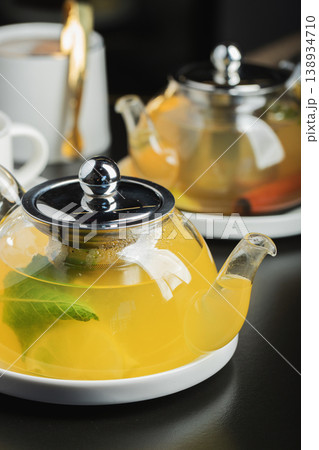 Fruit tea with mango and mint in a glass teapot on the table Fruit tea with mango and mint in a glass teapot on the table 138934710