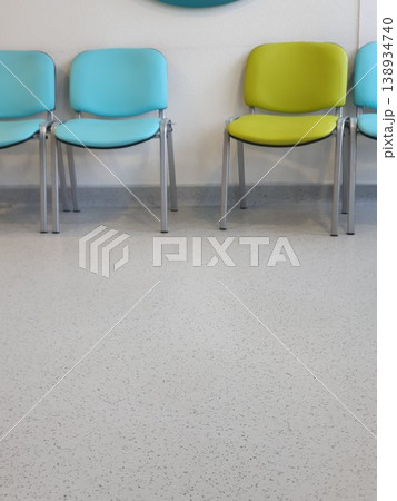 Phone photo of blue and green chairs in a hospital waiting area. Calm and organized interior scene showing seating, healthcare environment, and functional design. Phone photo of blue and green chairs in a hospital waiting area. Calm and organized interior scene showing seating, healthcare environment, and functional design. 138934740