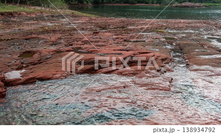Layered deep red sedimentary rock formations with fractures and water pools in the seaside which is a remote coastal spots in Hung Shek Mun (Red Stone Gate), Plover Cove Country Park, Hong Kong Layered deep red sedimentary rock formations with fractures and water pools in the seaside which is a remote coastal spots in Hung Shek Mun (Red Stone Gate), Plover Cove Country Park, Hong Kong 138934792