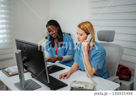 Medical receptionists collaborating on patient appointments and calls Medical receptionists collaborating on patient appointments and calls 138935498