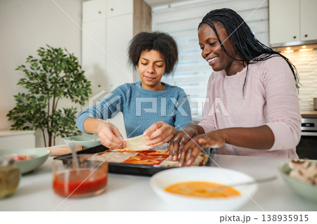 Mother and daughter bonding, making pizza from scratch at home 138935915