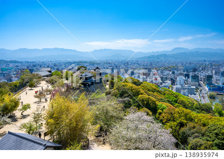 松山城本丸広場から望む松山市街地の眺望 新緑とビル群のパノラマ 138935974