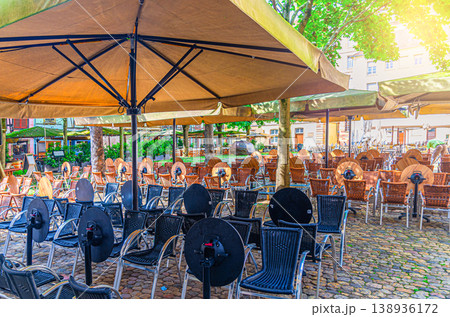 Rows of tables, chairs and umbrellas of street restaurant outdoor cafe Rows of tables, chairs and umbrellas of street restaurant outdoor cafe 138936172
