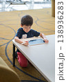 Young Boy Engaged with Tablet at Airport Lounge, Focused and Curious 138936283