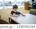 Young Boy Engaged in Creative Drawing at Airport Lounge with Modern Design 138936284