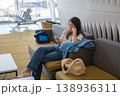 Young Woman Relaxing in Airport Lounge, Using Smartphone While Waiting for Flight 138936311