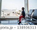 Young Boy Watching Airplane at Airport Terminal Window 138936313