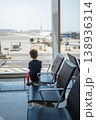 Young Boy Watching Airplane at Airport Terminal Window 138936314