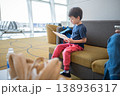 Young Boy Reading at Airport Lounge, Engaged in Activity While Waiting for Flight 138936317