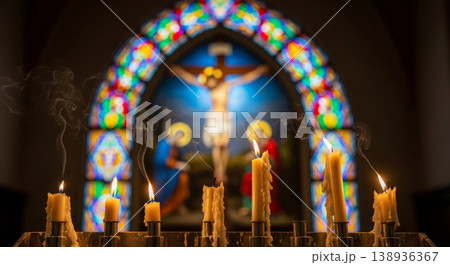 Mysterious church atmosphere with burning church candles on the background of a blurred crucifix Mysterious church atmosphere with burning church candles on the background of a blurred crucifix 138936367