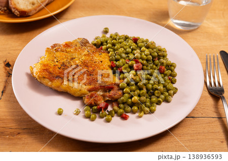 Fried crispy boneless skinless chicken with green peas on a plate in a restaurant Fried crispy boneless skinless chicken with green peas on a plate in a restaurant 138936593